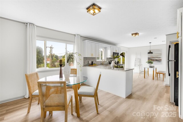 kitchen with white cabinets, sink, hanging light fixtures, tasteful backsplash, and kitchen peninsula