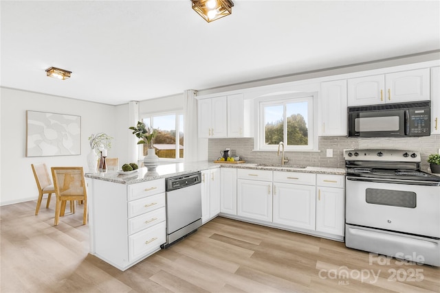 kitchen featuring dishwasher, sink, white electric range oven, light stone counters, and white cabinets