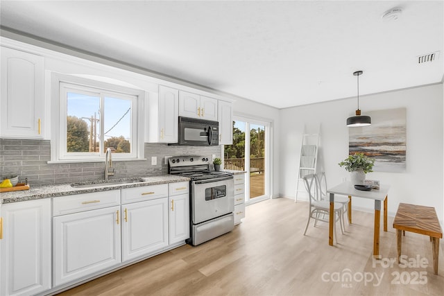 kitchen with sink, hanging light fixtures, light stone counters, stainless steel electric stove, and white cabinets