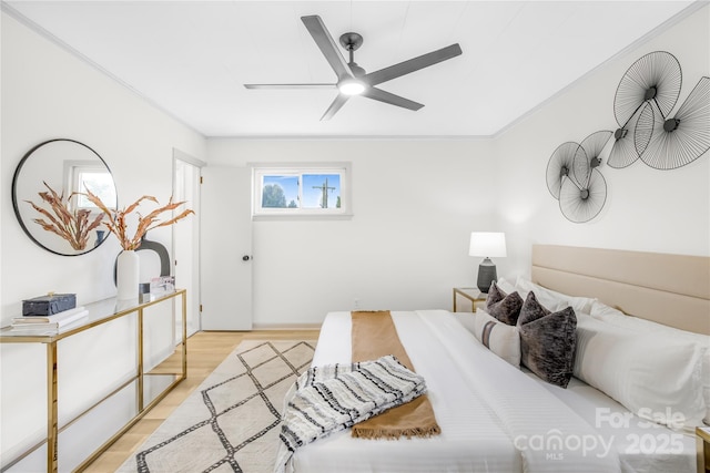 bedroom featuring ceiling fan, light hardwood / wood-style floors, and ornamental molding