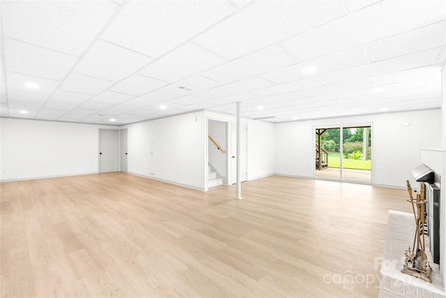 basement with light hardwood / wood-style flooring and a drop ceiling