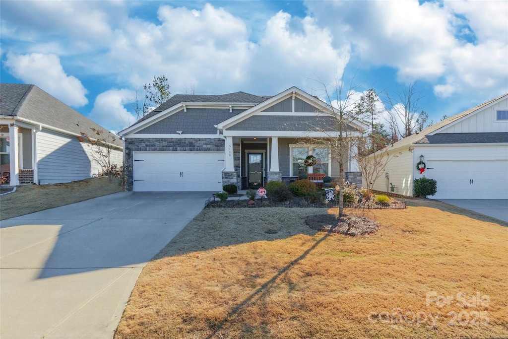 craftsman inspired home featuring a front yard and a garage