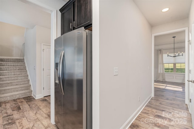 kitchen featuring stainless steel fridge with ice dispenser, decorative light fixtures, light hardwood / wood-style flooring, and a notable chandelier