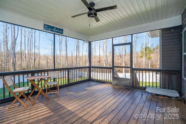 unfurnished sunroom with ceiling fan