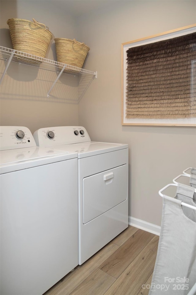 clothes washing area featuring washing machine and dryer and light hardwood / wood-style floors