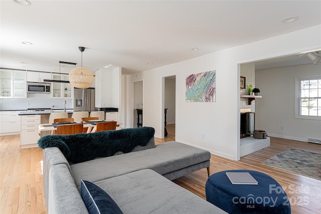 living room with light hardwood / wood-style flooring and a fireplace