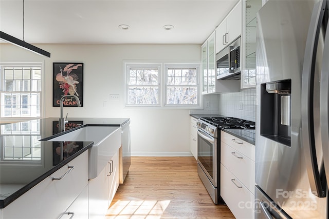 kitchen featuring white cabinetry, plenty of natural light, stainless steel appliances, and light hardwood / wood-style floors