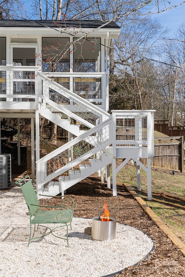 view of home's exterior with central air condition unit and a fire pit