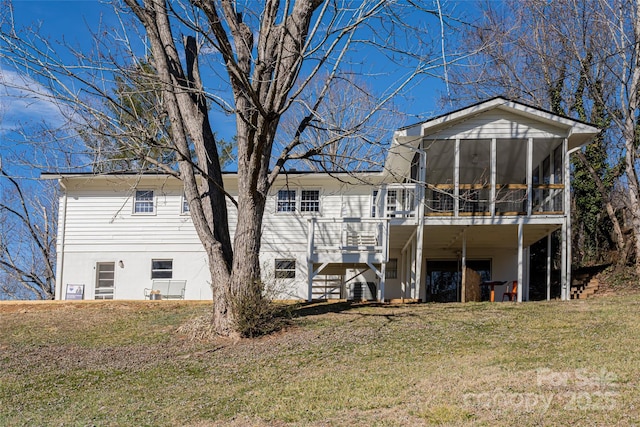 back of property with a yard and a sunroom