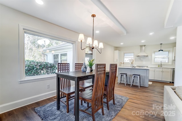 dining space with dark hardwood / wood-style floors, sink, and a chandelier