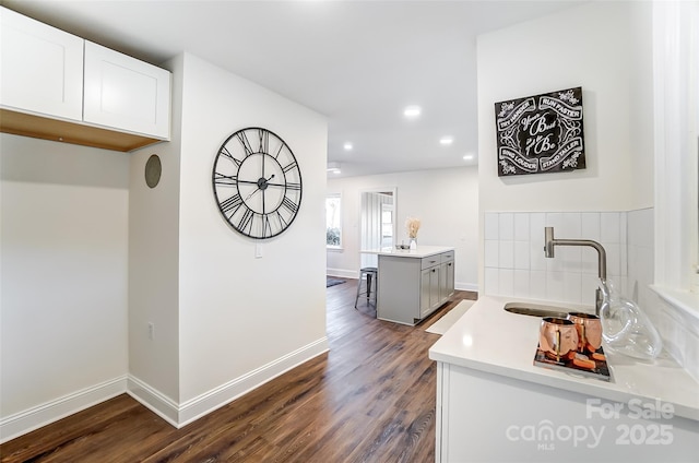 kitchen with dark hardwood / wood-style floors, white cabinetry, and sink