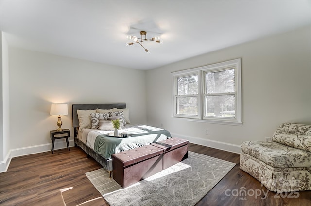 bedroom with dark hardwood / wood-style flooring and an inviting chandelier