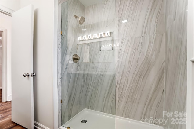 bathroom featuring wood-type flooring and tiled shower