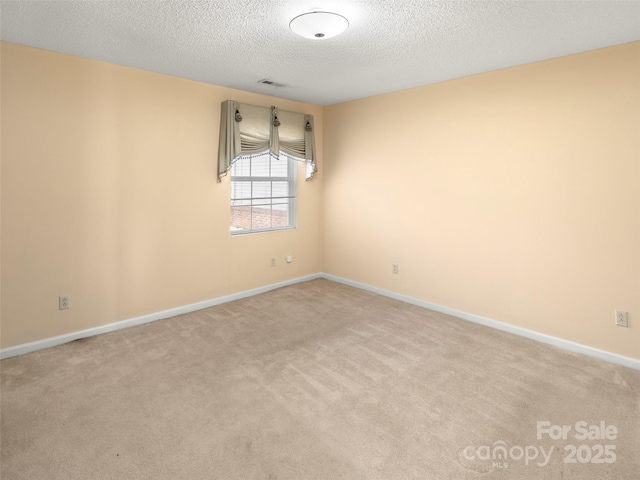 carpeted spare room with a textured ceiling