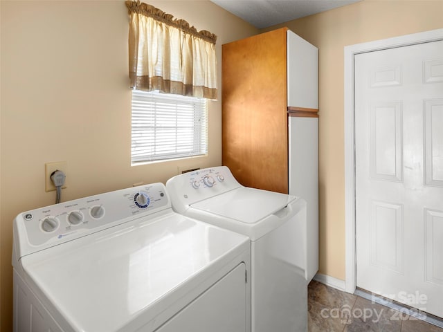 laundry room featuring tile patterned floors, washer and clothes dryer, and cabinets