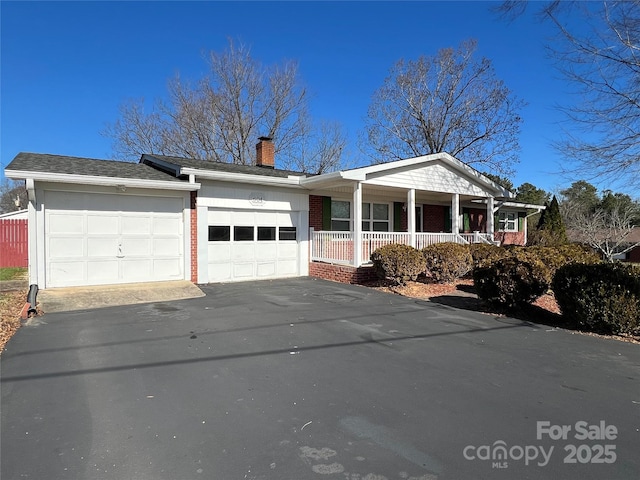 ranch-style house featuring a porch and a garage