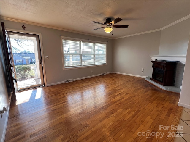 unfurnished living room with wood-type flooring, a textured ceiling, ceiling fan, and ornamental molding