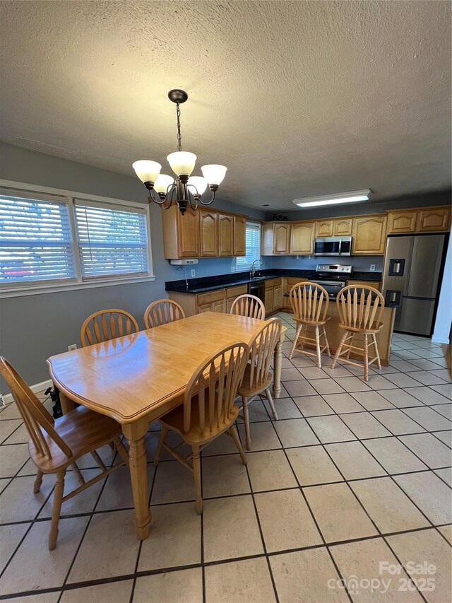 dining space featuring a chandelier, a textured ceiling, and light tile patterned flooring