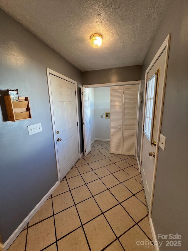 interior space featuring light tile patterned floors and a textured ceiling