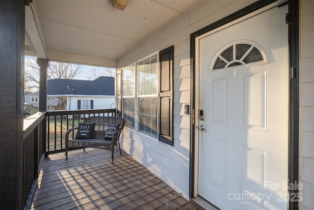 view of exterior entry featuring covered porch