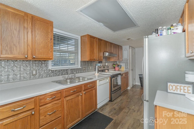 kitchen featuring backsplash, dark wood-type flooring, sink, a textured ceiling, and stainless steel appliances