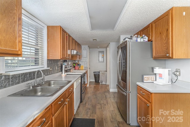 kitchen with backsplash, sink, a textured ceiling, appliances with stainless steel finishes, and dark hardwood / wood-style flooring