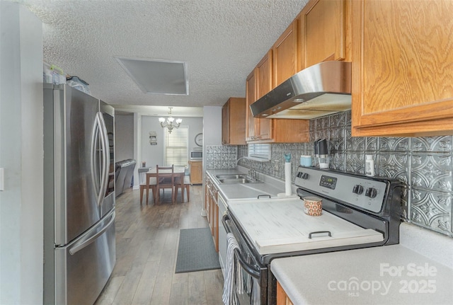 kitchen featuring stainless steel refrigerator, electric range oven, light hardwood / wood-style flooring, range hood, and decorative backsplash