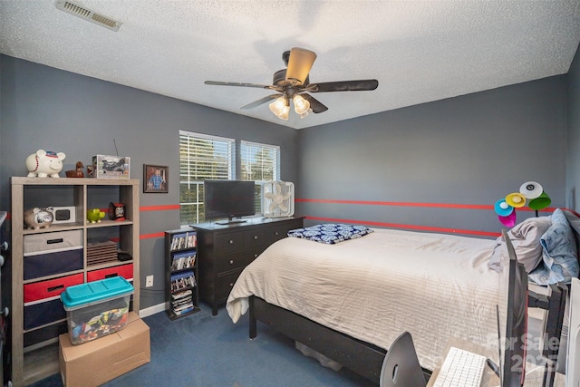 carpeted bedroom with ceiling fan and a textured ceiling