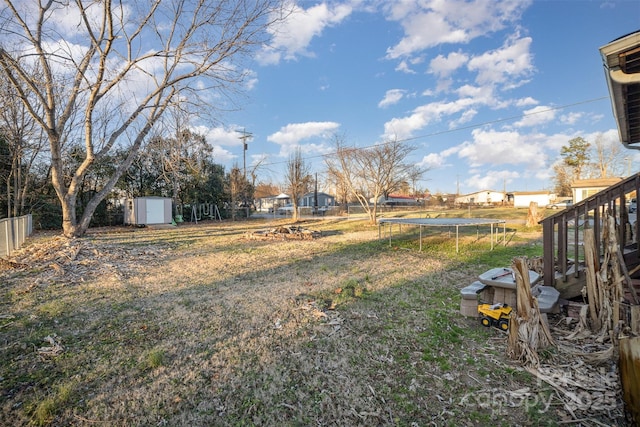 view of yard featuring a storage unit and a trampoline