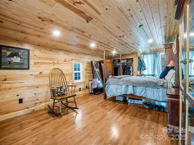 bedroom with hardwood / wood-style floors, wooden walls, vaulted ceiling, wood ceiling, and a closet