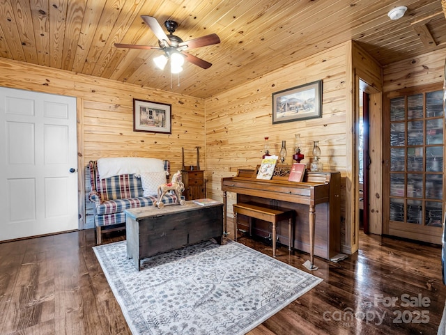 interior space featuring dark hardwood / wood-style floors, ceiling fan, wooden ceiling, and wooden walls