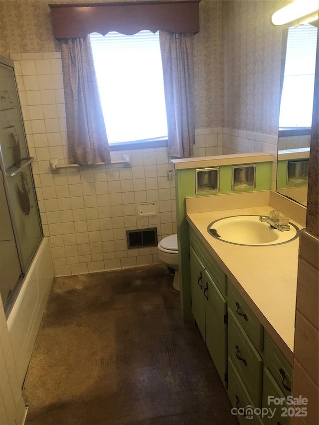 full bathroom with vanity, a healthy amount of sunlight, tile walls, and toilet