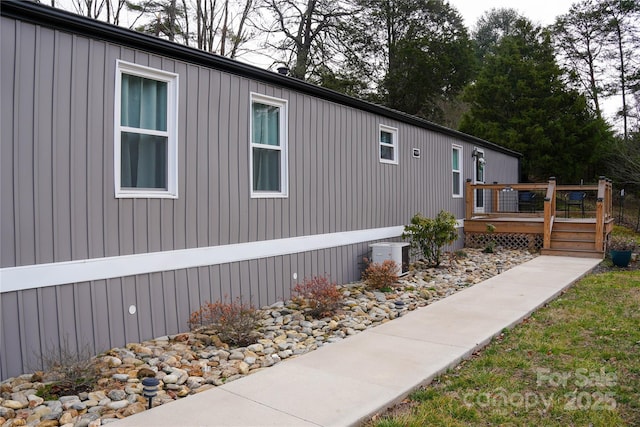 view of property exterior with central AC and a wooden deck