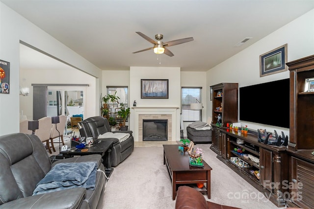 carpeted living room with ceiling fan and a fireplace