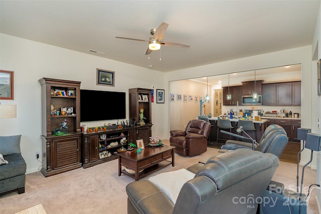 carpeted living room with ceiling fan