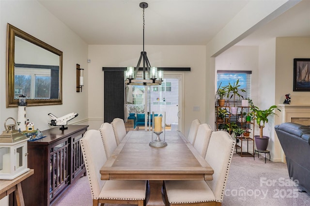 dining area featuring light carpet and a notable chandelier