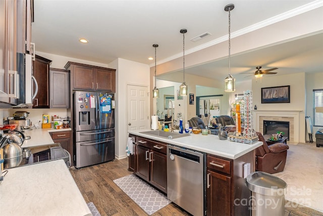 kitchen featuring pendant lighting, ceiling fan, dark hardwood / wood-style floors, a kitchen island, and stainless steel appliances