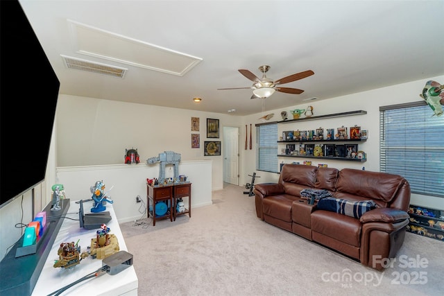 carpeted living room with ceiling fan