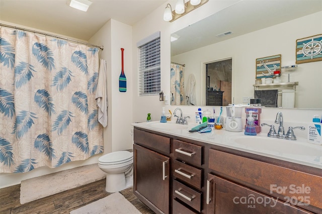 bathroom featuring vanity, hardwood / wood-style flooring, and toilet