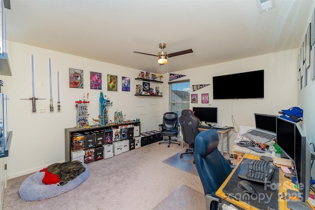 carpeted home office featuring ceiling fan