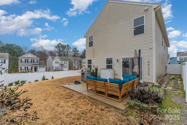 back of property with an outdoor living space and a patio