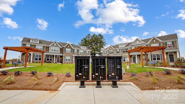 view of home's community featuring a lawn, mail area, and a pergola