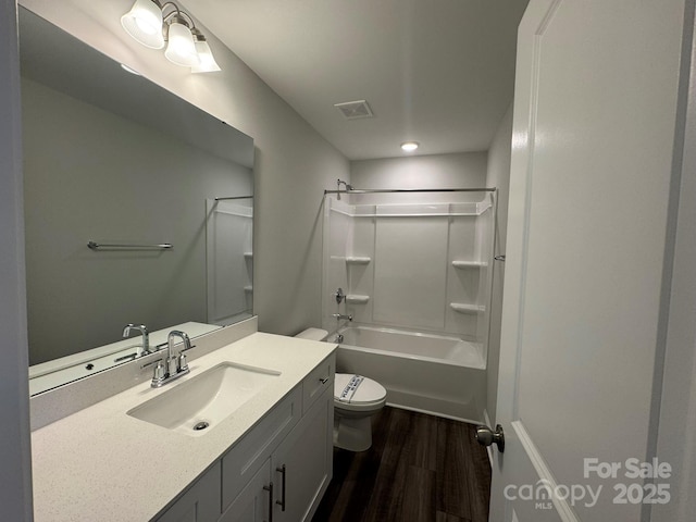 bathroom with visible vents, toilet, shower / bathtub combination, wood finished floors, and vanity