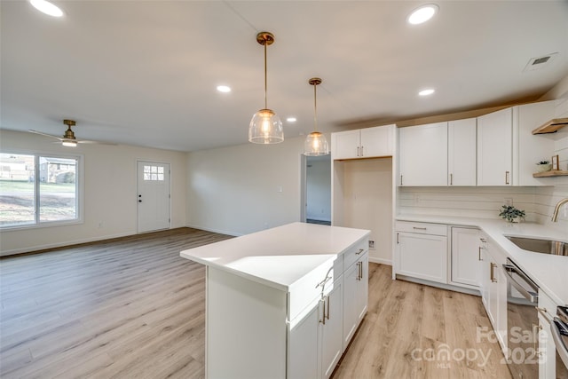 kitchen with dishwasher, sink, ceiling fan, tasteful backsplash, and white cabinetry