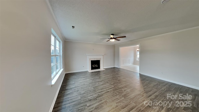 unfurnished living room featuring crown molding, ceiling fan, dark hardwood / wood-style floors, and a textured ceiling