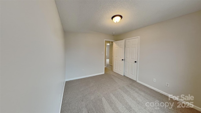 carpeted empty room featuring a textured ceiling