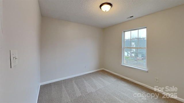 carpeted spare room featuring a textured ceiling