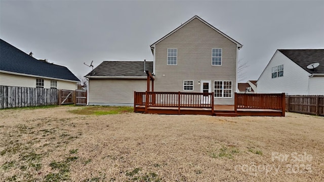 rear view of house with a yard and a deck