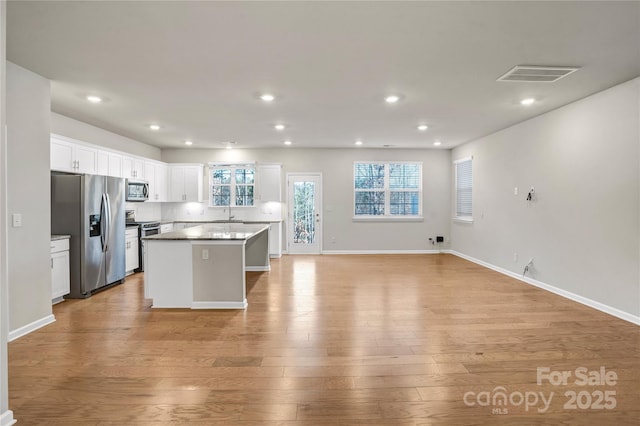 kitchen featuring white cabinetry, a center island, light hardwood / wood-style flooring, and appliances with stainless steel finishes