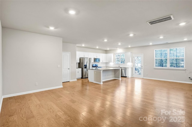 unfurnished living room with light hardwood / wood-style floors and sink